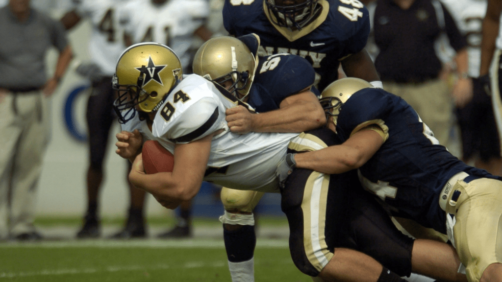 a football player is being tackled by other players