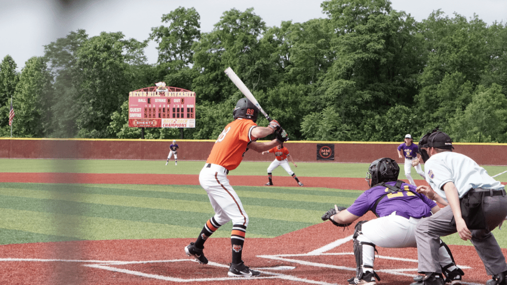 a baseball player swinging at a pitch