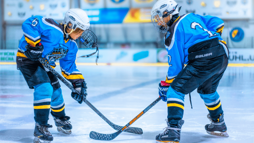 two young playing hockey on an ice rink