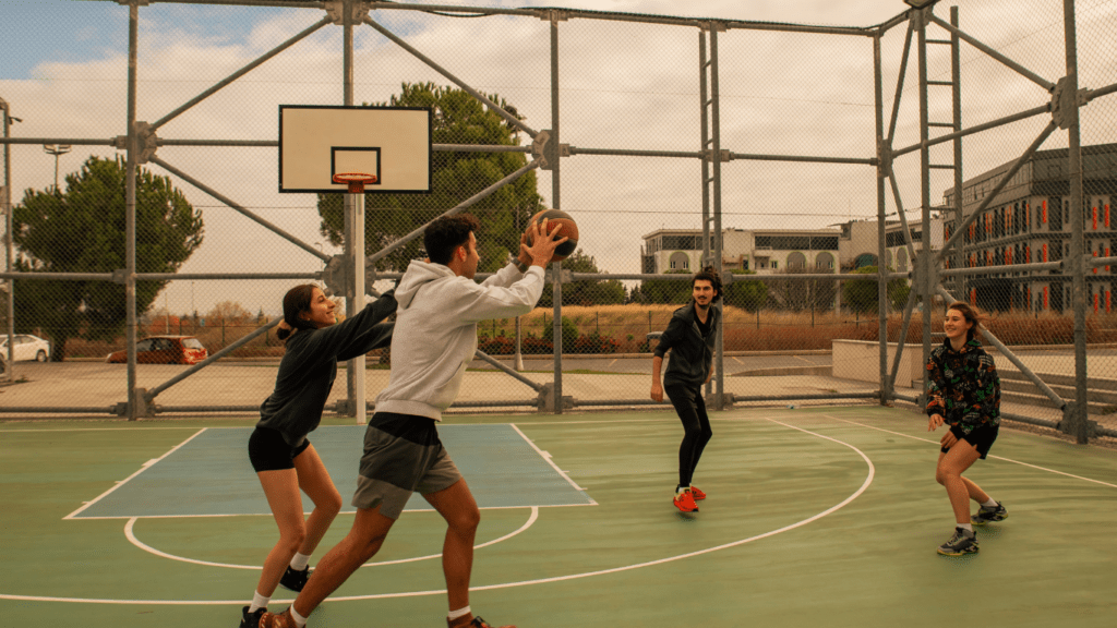 a group of people playing basketball on an outdoor court