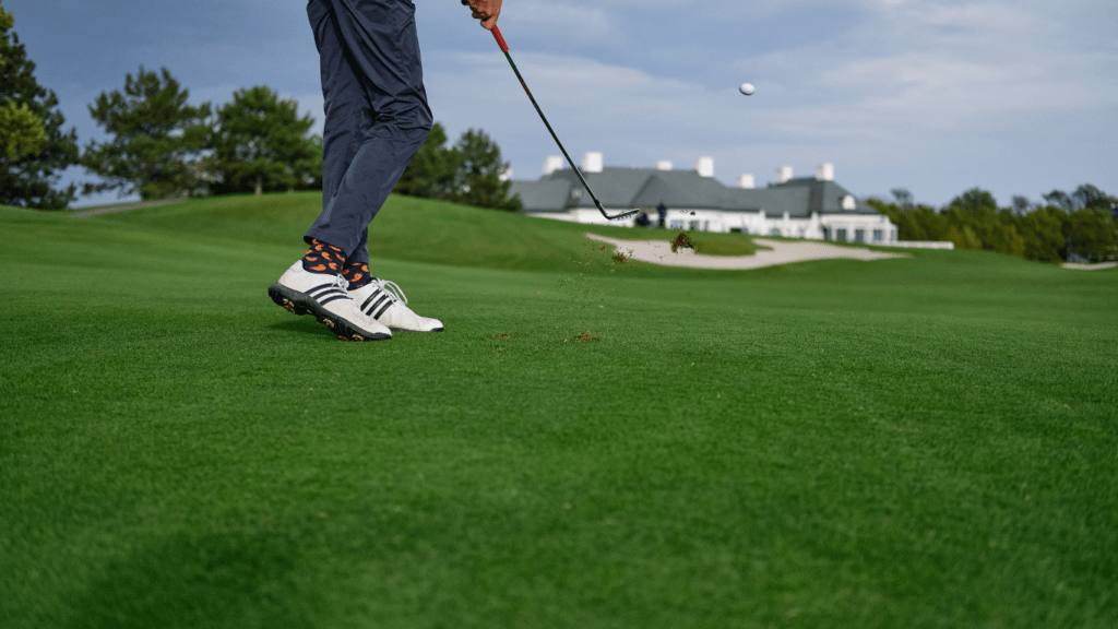 a person on a golf course hitting a golf ball