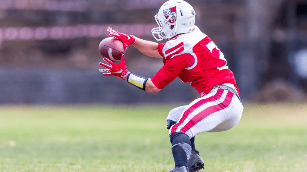 a football player catches the ball during a game