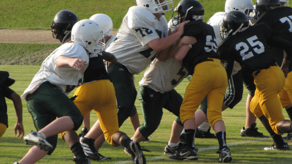 a football player is being tackled by other players