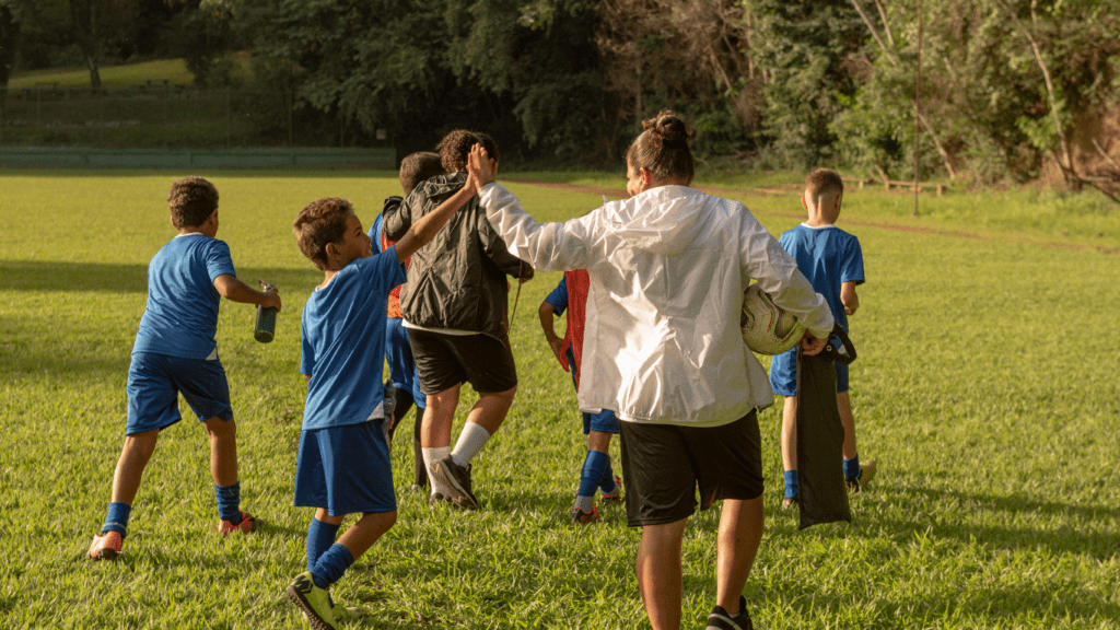 a group of individuals in soccer uniforms standing around a coach