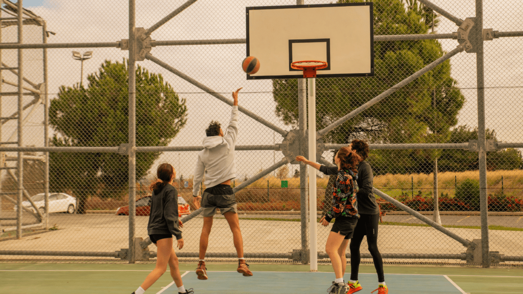 a group of people playing basketball on an outdoor court