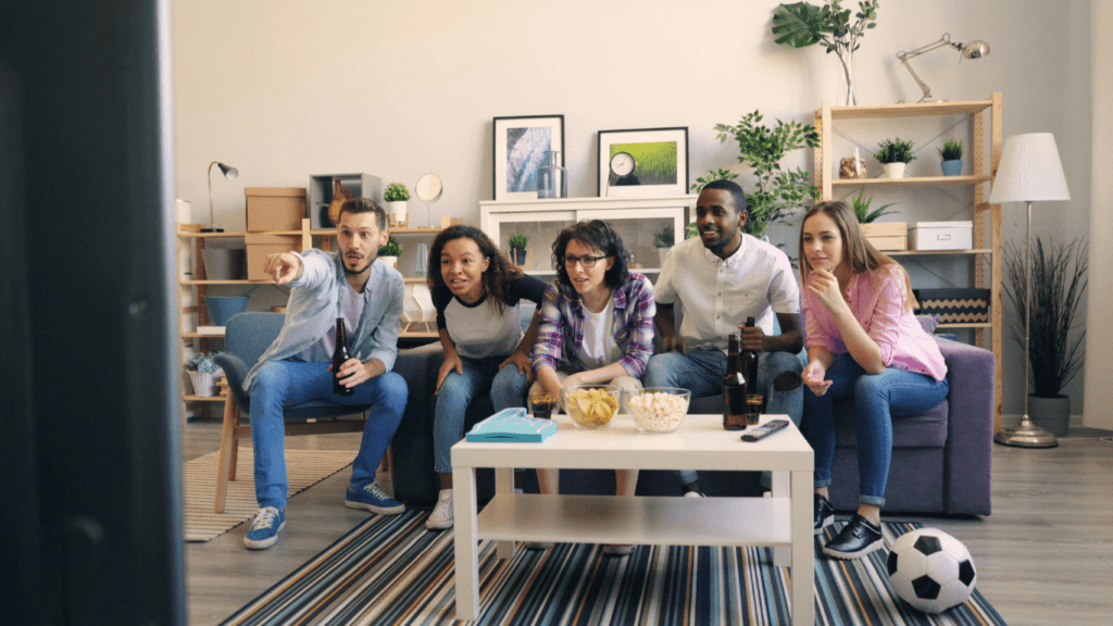 a group of people sitting on a couch watching TV