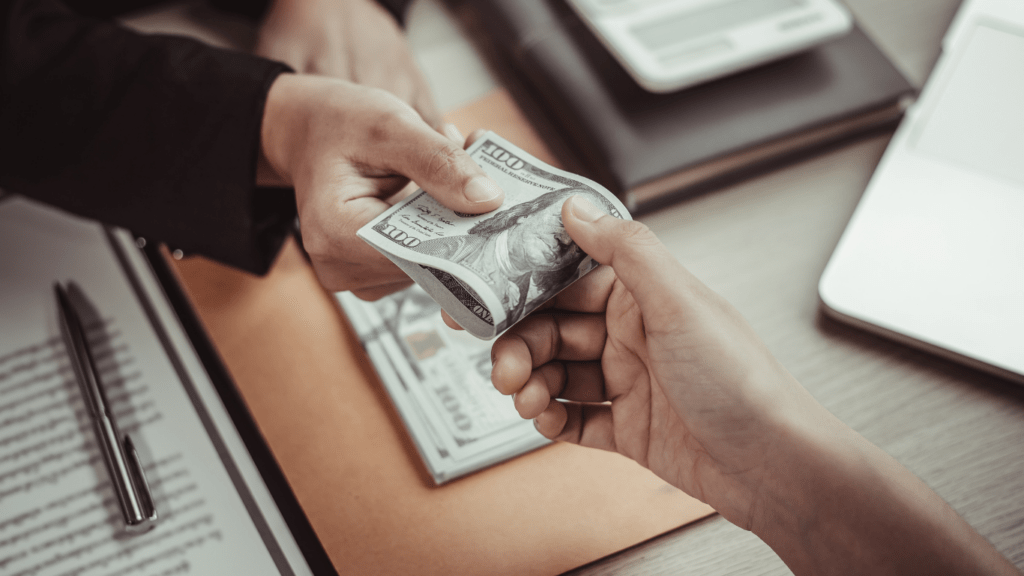 a person handing money to another person at a desk