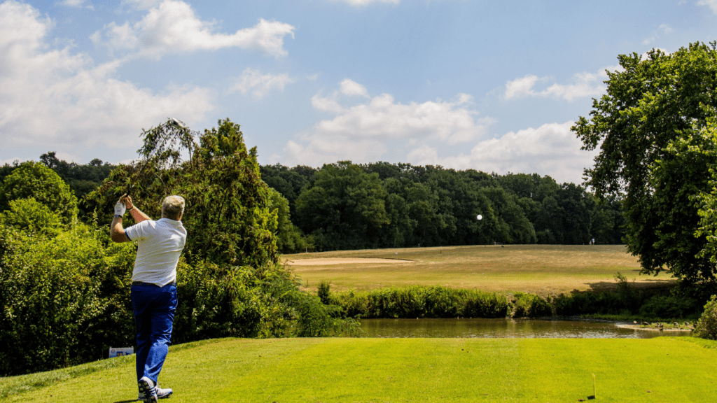 a person on a golf course hitting a golf ball