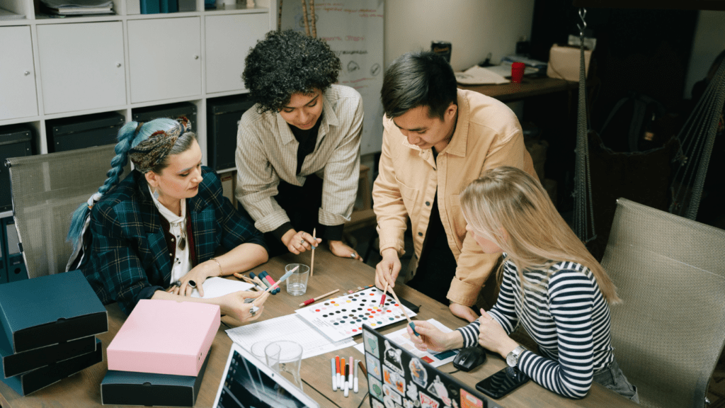 people sitting at a table with papers and a laptop